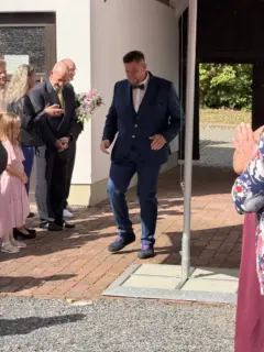 Christian zieht im blauen Anzug zwischen den applaudierenden Gästen ein